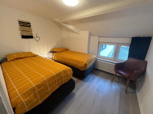 埃彭Apartment Top van Epen的一间设有两张床和椅子的房间