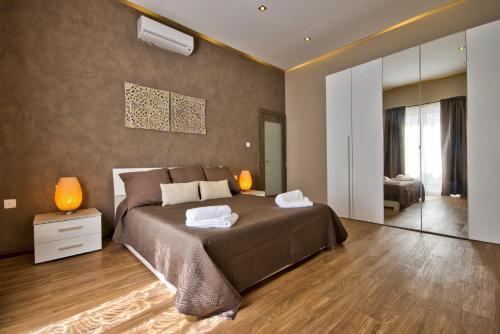 梅利哈Villa Goa - By Luxury Villas Malta的一间卧室设有一张大床和一个大镜子