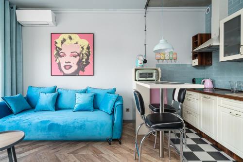 弗罗茨瓦夫RentPlanet - Apartamenty Zarembowicza的一间带蓝色沙发的客厅和一间厨房