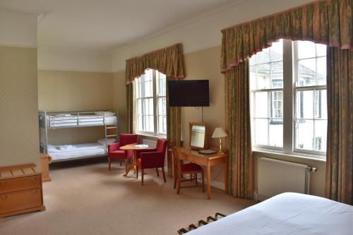 金罗斯绿色酒店的一间卧室配有一张床、一张桌子、一张床和窗户。