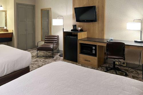 奥古斯塔Maine Evergreen Hotel, Ascend Hotel Collection的酒店客房配有一张床和一张书桌及一台电视