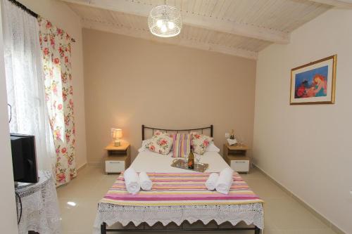 卡拉马孔Kouros resort的一间卧室配有一张床和一台电视。