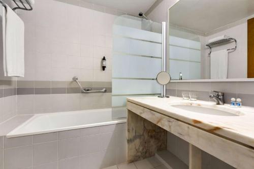 蒙蒂茹TRYP by Wyndham Montijo Parque Hotel的一间带水槽、浴缸和镜子的浴室