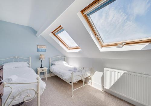 斯沃尼奇Sea View Villa的阁楼卧室设有两张床和窗户。