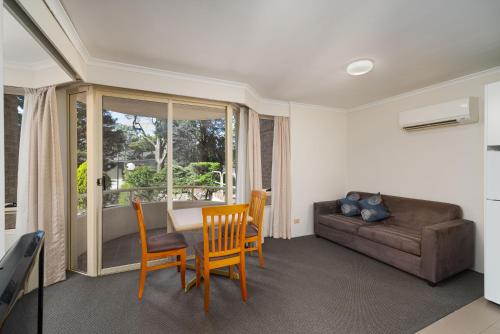 霍恩斯比Wahroonga Furnished Apartments的客厅配有沙发和桌椅