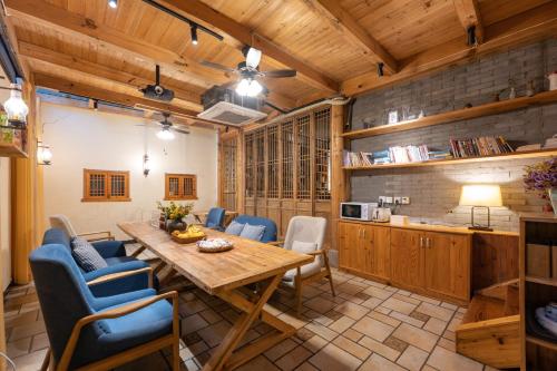 黄山市黄山和春徽姑娘民宿的厨房以及带木桌和椅子的用餐室。