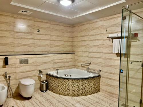 沙迦沙迦国敦大酒店的带浴缸和卫生间的浴室。