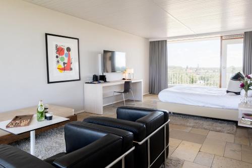 布雷斯肯斯米利阿诺酒店的酒店客房配有床、沙发和桌子。