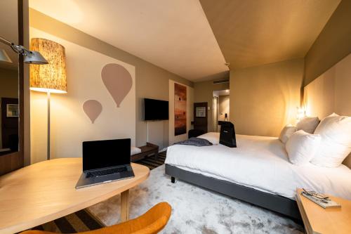 梅朗梅朗格勒诺布尔美居酒店的酒店客房配有一张床、一张书桌和一台笔记本电脑