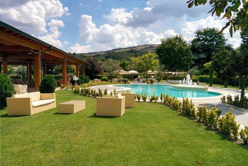Castropignano德维里别墅酒店的草原上带游泳池和椅子的度假村