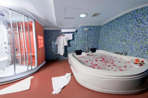 奎隆奎隆海滩酒店及会议中心的浴室设有花卉覆盖的浴缸。