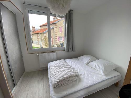 Fleury-sur-AndelleMaison de ville的卧室内的一张未铺好的床,设有窗户