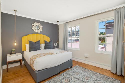开普敦Shortmarket 136的一间卧室配有一张带黄色床头板的大床