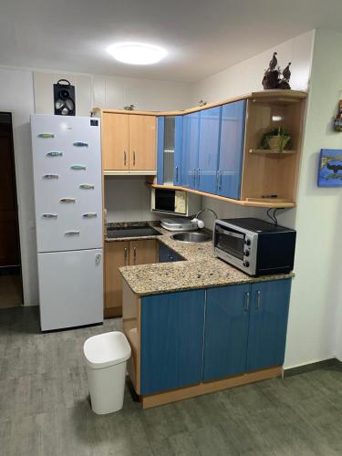 拉曼加戴尔马尔梅纳Apartamento Geminis的厨房配有蓝色橱柜和白色冰箱