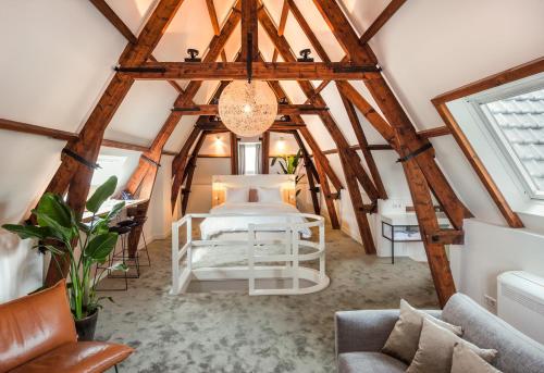 阿姆斯特丹亚瑞娜酒店的一间带一张床的卧室,位于带木制天花板的房间内