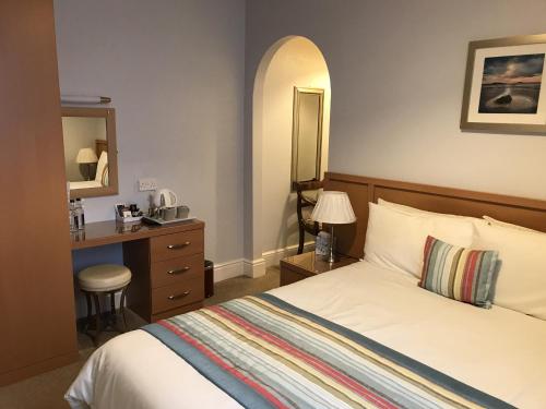 绍斯波特The Bowden Lodge的一间卧室配有一张床、一张书桌和一面镜子