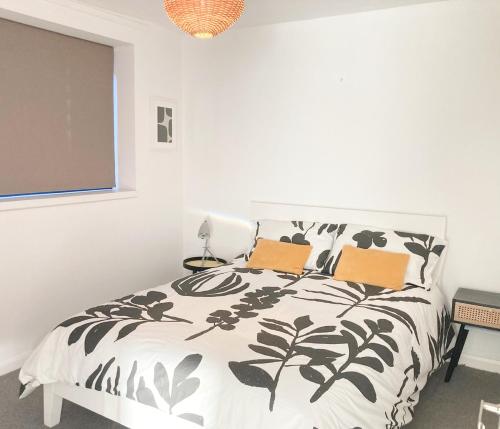 诺里奇Philippa Court Grade II townhouse- 3 bedrooms- free parking的卧室配有黑色和白色的床和2个枕头