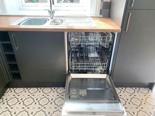 哈沃斯Artist Hideaway Main Street Haworth的厨房里配有一个空洗碗机,厨房里设有水槽