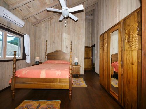 西湾Hummingbird Beach House的一间卧室配有一张床和吊扇