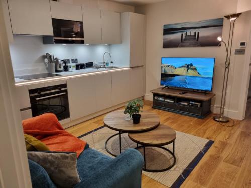 圣奥尔本斯Ritual Stays stylish 1-Bed Flat in the Heart of St Albans City Centre with Working Space and Super Fast WiFi的带沙发、桌子和电视的客厅