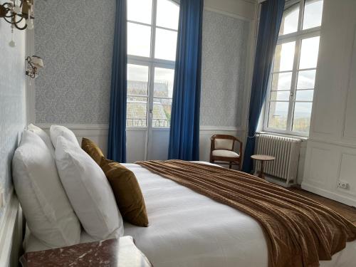富热尔Mercier de Montigny - Les Chambres du Beffroi - SPA et Massage的一间卧室配有一张带蓝色窗帘的大床