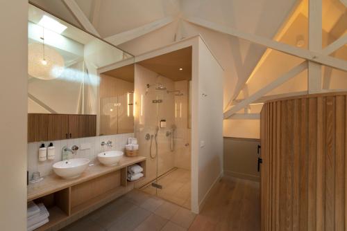 阿姆斯特丹亚瑞娜酒店的大型浴室设有2个水槽和淋浴。