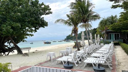 丽贝岛利普岛贝拉维斯塔海滩度假酒店的沙滩上的一排白色椅子