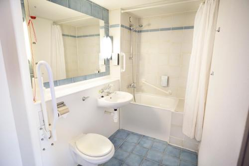 巴塞尔顿钟楼伦敦东区巴斯尔登酒店的浴室配有卫生间、盥洗盆和浴缸。