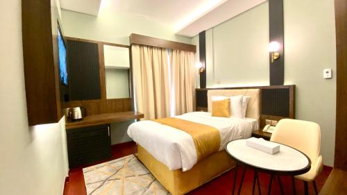 迪拜Concorde Inn Hotel的酒店客房设有一张床和一张小桌子。