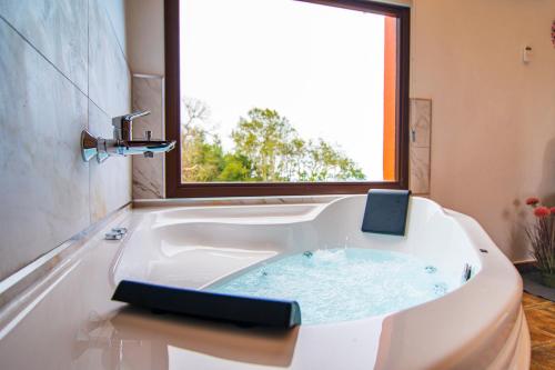 塔科龙特Finca El Pastel的浴室设有白色浴缸和窗户。