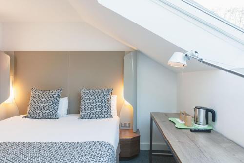 布隆钟楼里昂布隆厄尔波酒店的一间卧室配有一张床和一张木桌