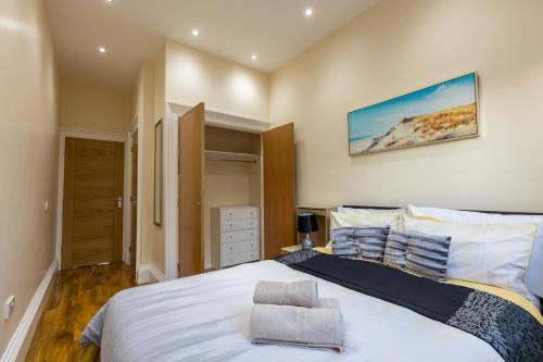 爱丁堡New 3-Bedroom Apartment Close to City Centre的卧室配有一张白色大床和椅子