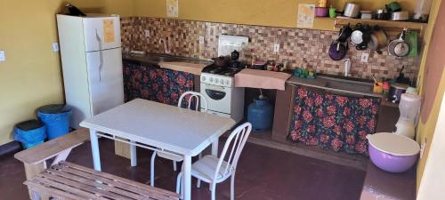 韦尔卡鲍Do Alto da Montanha Pousada的一间带桌子和冰箱的小厨房