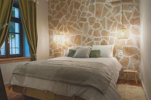 约阿尼纳locanta的一间卧室设有一张带石墙的大床