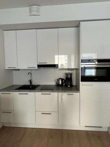 万塔City apartment nearby Airport的白色的厨房配有白色橱柜和水槽