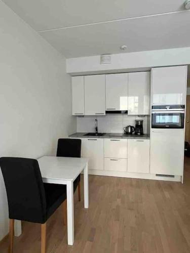 万塔City apartment nearby Airport的厨房配有白色橱柜和桌椅