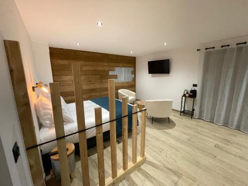 昂塞勒Appart Hôtel Le JAS的一间卧室配有一张带木制床头板的床