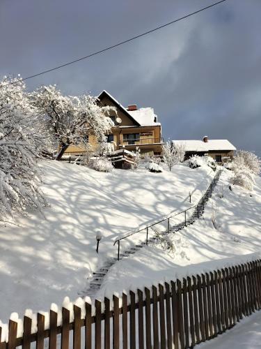 维斯瓦Agroturystyka Na Kępie的雪覆盖的院子,有房子和栅栏