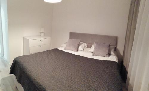 新苏尔Apartament MajaHouse的一间卧室配有一张大床和一个白色梳妆台