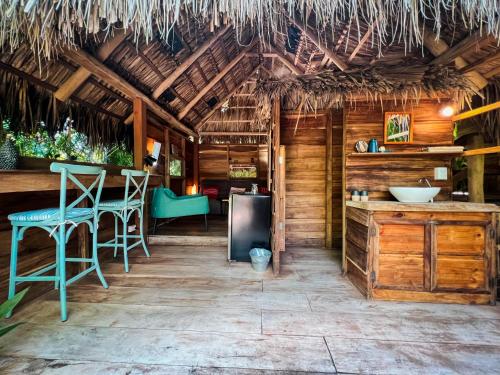 格兰德海滩Glamping Hotel Flor y Bambu的小屋内的厨房配有蓝色椅子和酒吧