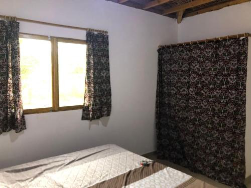 Boukot OuolofSénégal CASAMANCE的一间卧室设有一张床和一个窗口
