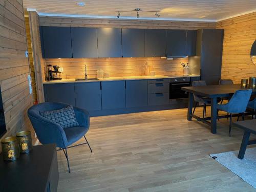 斯屈勒斯塔穆New modern apartment with great view - ski in & out的厨房配有蓝色橱柜和桌椅