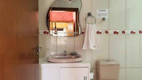 卡内拉Casa Palace Canela的一间带水槽、镜子和卫生间的浴室