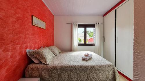 卡内拉Casa Palace Canela的一间设有红色墙壁的小卧室