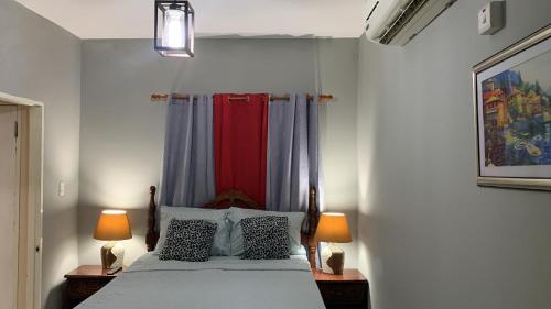 蒙特哥贝N & A PALACE的一间卧室配有一张带两张台灯的床铺。