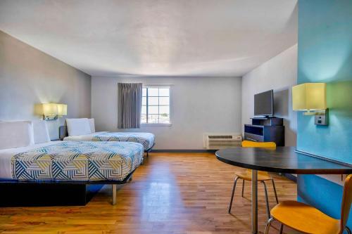 亚瑟港Studio 6-Port Arthur, TX - SE的酒店客房设有两张床和一张桌子。
