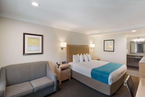 伍德兰希尔斯Best Western Woodland Hills的配有一张床和一把椅子的酒店客房