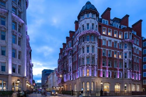 伦敦Radisson Blu Edwardian Kenilworth Hotel, London的黄昏时分,在城市街道上一座大建筑