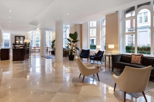 伦敦Radisson Blu Kenilworth Hotel, London的大楼内带椅子和沙发的大堂
