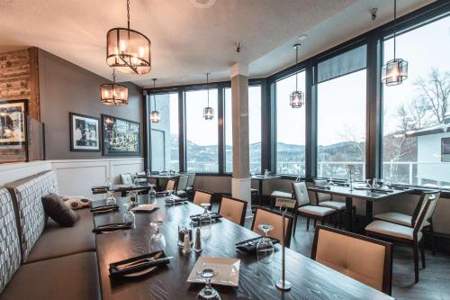 罗斯兰罗斯兰威望山度假酒店的餐厅设有桌椅和大窗户。